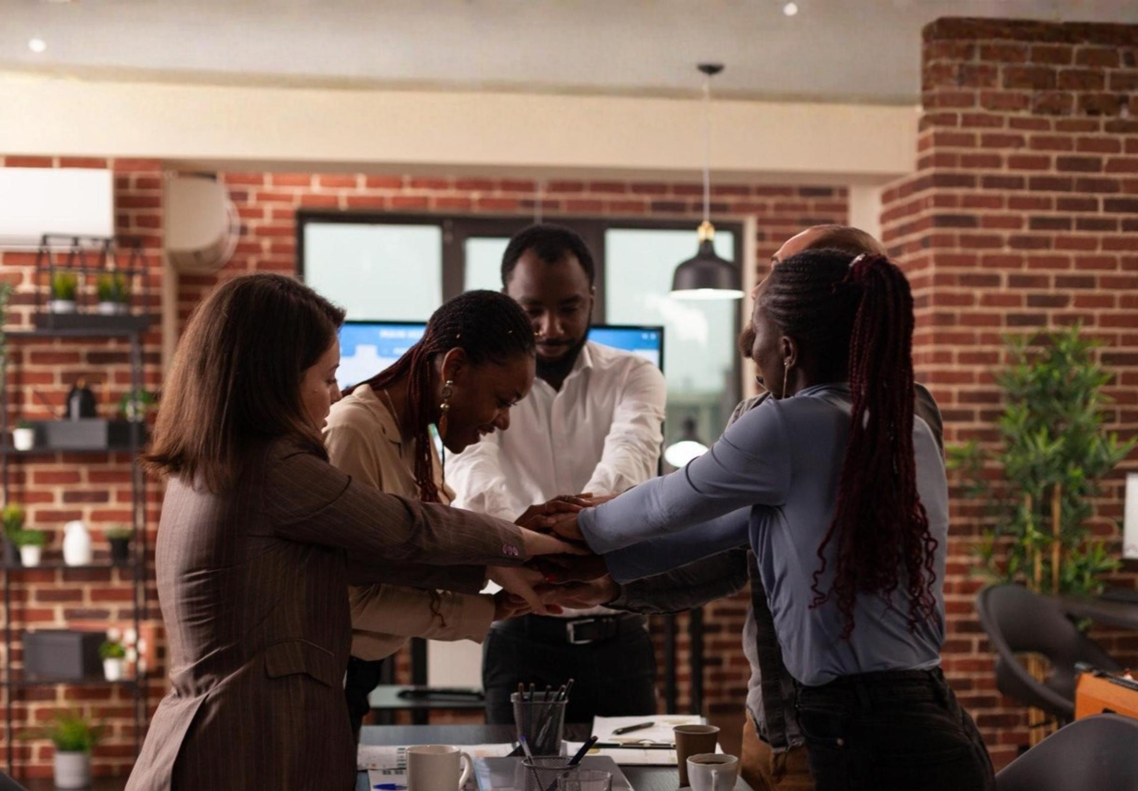A diverse group of employees laughing and smiling in a collaborative work environment.